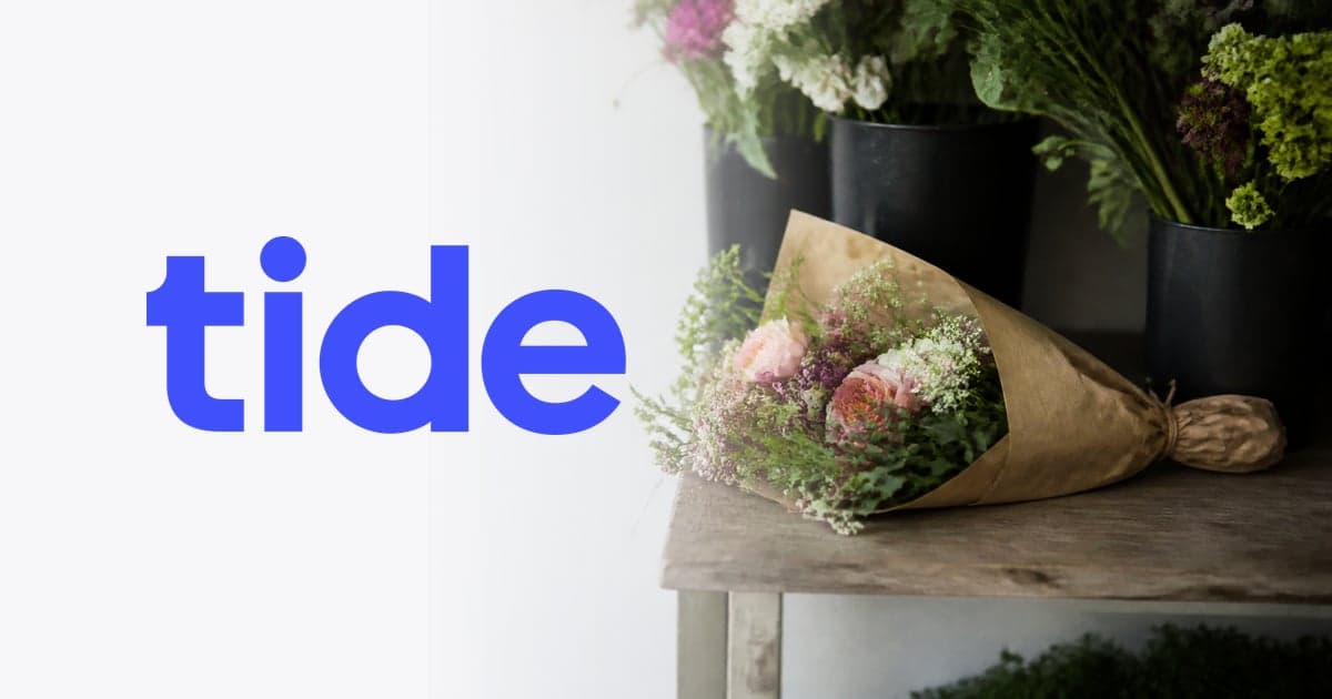 a florist’s workbench with buckets of cut stems and a wrapped bouquet
