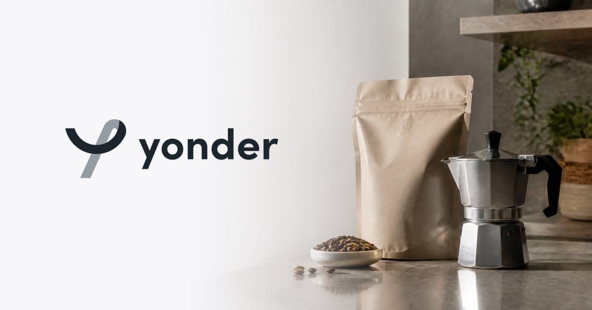a bag of speciality coffee beans and a stovetop moka pot on a pale kitchen counter in morning light
