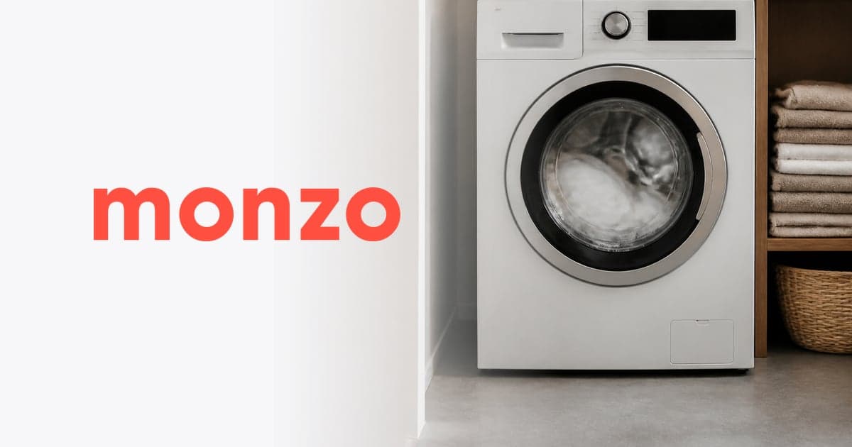 a washing machine mid cycle in a small utility room beside a pile of folded towels
