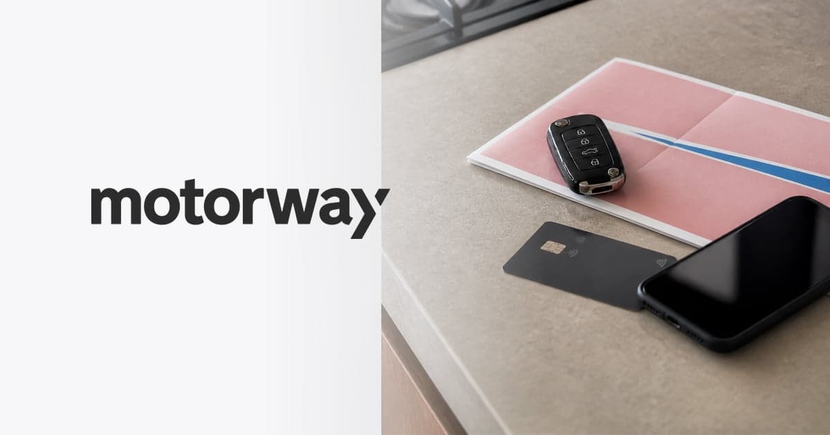 a car key fob and a V5C logbook lying on a kitchen worktop beside a debit card and a phone