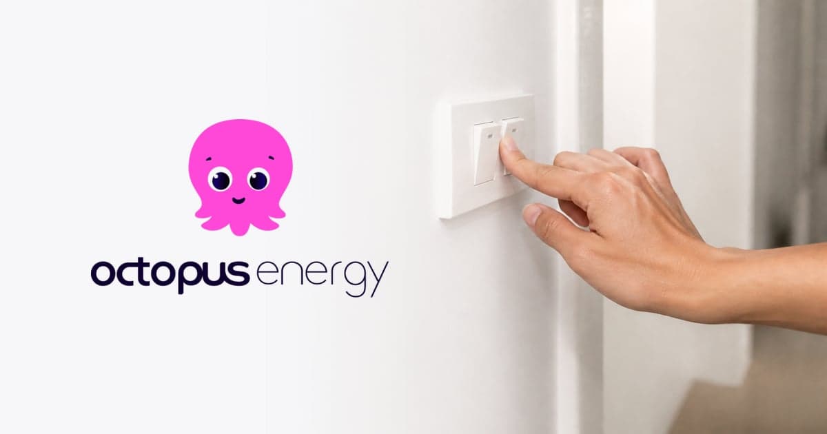 a hand switching on a wall light switch in a plain white hallway